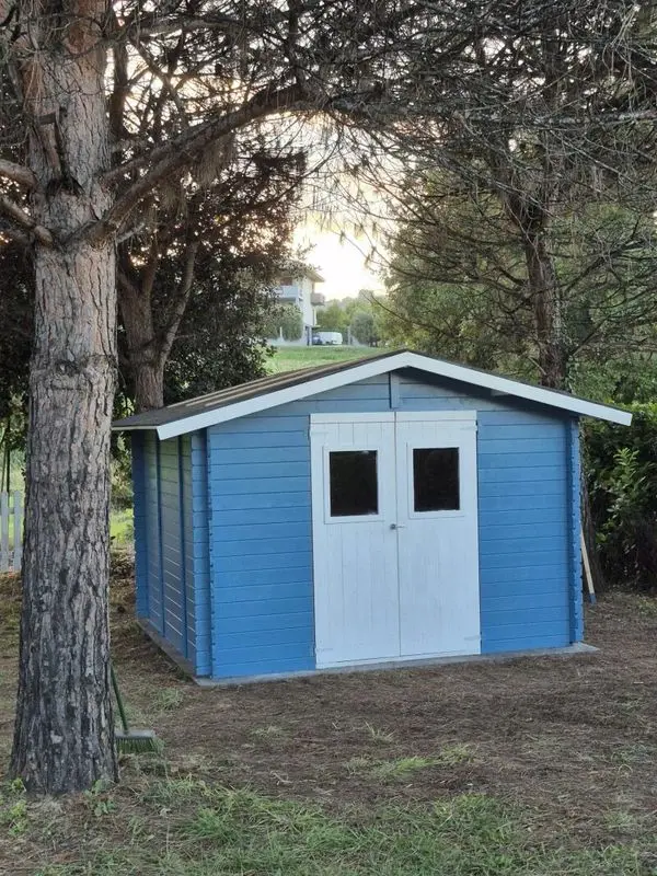 Una casetta dipinta di azzurro in giardino